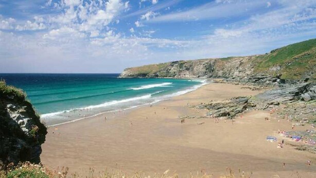 A beach with a rocky coastline, clear blue water, and a sandy shore. - 3 Bed in Tintagel (oc-e32938) (Tintagel)