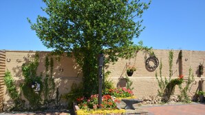 A courtyard with a brick pathway, a tree, and flower beds. - 2 Bed in Blofield Heath (oc-1467) (Hemblington)