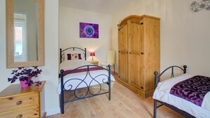 A bedroom with a bed, a wardrobe, a dresser, a mirror, a chandelier, and a wall art piece. - 2 Bed in Blofield Heath (oc-1467) (Hemblington)
