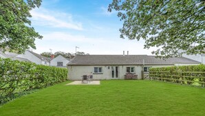 A house with a well-maintained lawn, a patio with outdoor furniture, and a wooden fence. - 1 Bed in Llandeloy (oc-c32808) (Llandeloy)