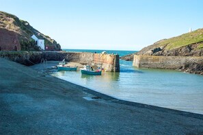 A coastal harbor with boats docked, a stone structure, and a building on the left. - 1 Bed in Llandeloy (oc-c32808) (Llandeloy)