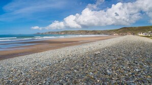 A pebble beach with a view of the sea and distant hills. - 1 Bed in Llandeloy (oc-c32808) (Llandeloy)