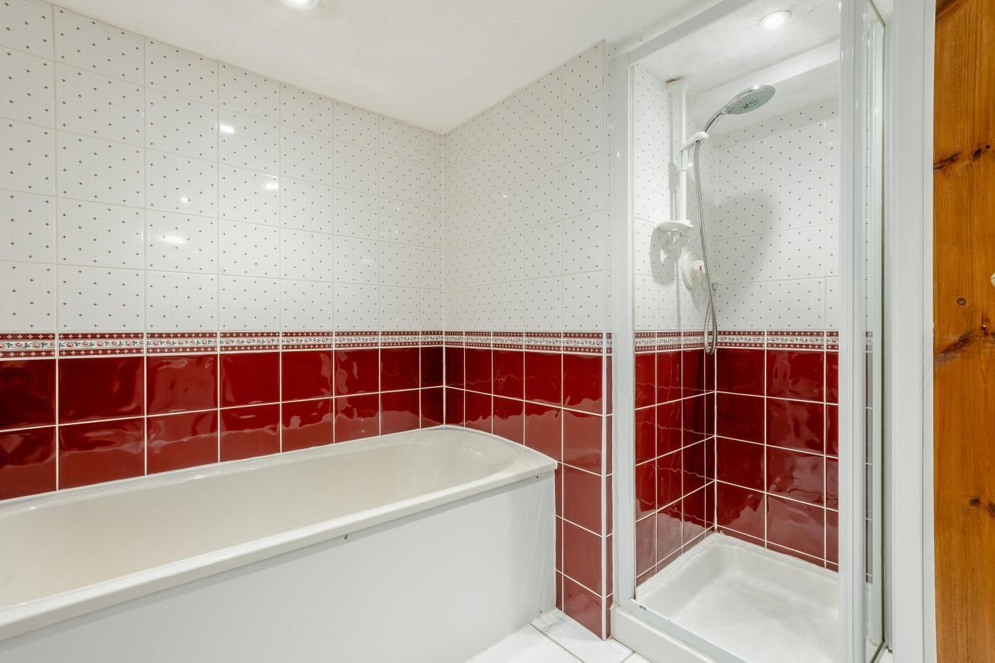 Une salle de bain avec une baignoire, une douche et des murs carrelés.