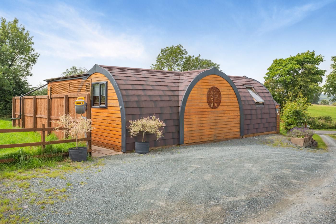 A wooden barn with a sloped roof, a wooden door, and a small window.