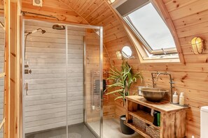 A wooden cabin with a skylight, a glass shower enclosure, a sink with a basin, and a potted plant. - 1 Bed in Horton (oc-b32803) (Horton)