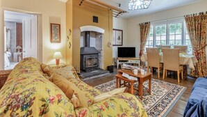 A cozy living room with a sofa, a fireplace, a television, and a dining area with chairs and a table. - 2 Bed in Knighton (oc-t32800) (Whitton)