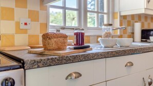 A kitchen with a loaf of bread, a jar of jam, and a bowl on the counter. - 2 Bed in Knighton (oc-t32800) (Whitton)