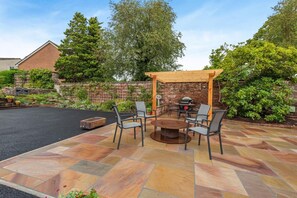 An outdoor patio with stone flooring, a round table, and four chairs. - 1 Bed in Wetheral (oc-r32933) (Great)