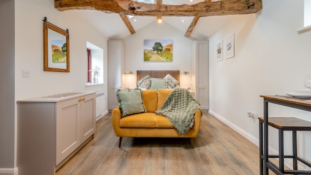 A modern interior with a yellow sofa, wooden beams, and artwork on the walls. - 1 Bed in Wetheral (oc-r32933) (Great)