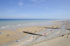 A beach with a wide promenade, calm waters, and a clear sky. - 3 Bed in Cromer (oc-1670) (Cromer)