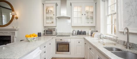 Een oven, een vaatwasser, kookgerei, borden en bestek