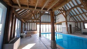 An indoor swimming pool with wooden beams and large windows. - 1 Bed in Maidstone (oc-md435) (Linton)
