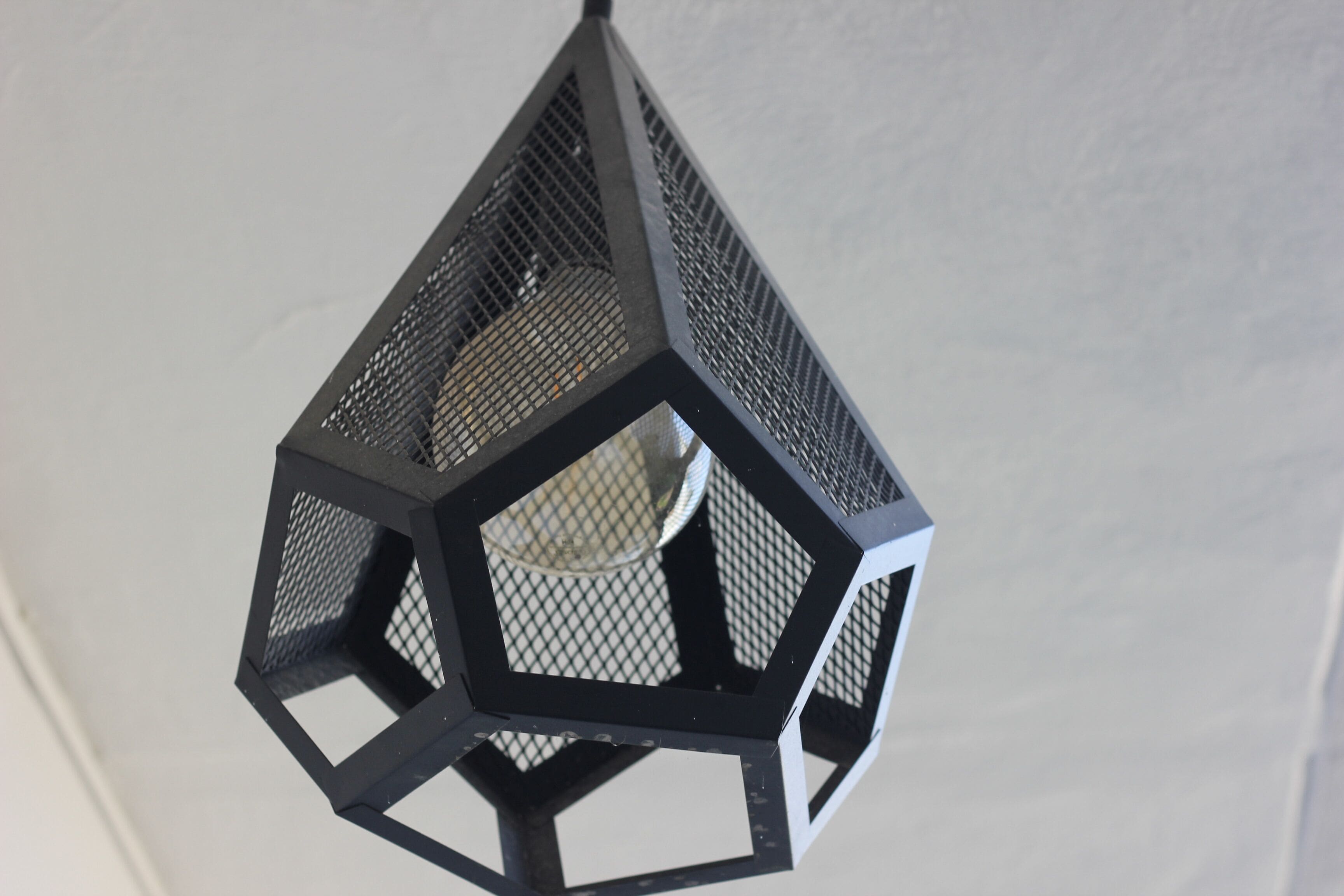 A geometric, black metal lantern with a hexagonal design.