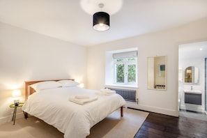 A bedroom with a bed, bedside lamps, a window, a radiator, and a bathroom visible through an open door. - 5 Bed in Ulpha (oc-b32731) (Ulpha)