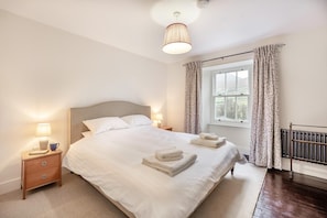 A neatly made bed with white linens, a bedside lamp, and a window with curtains. - 5 Bed in Ulpha (oc-b32731) (Ulpha)