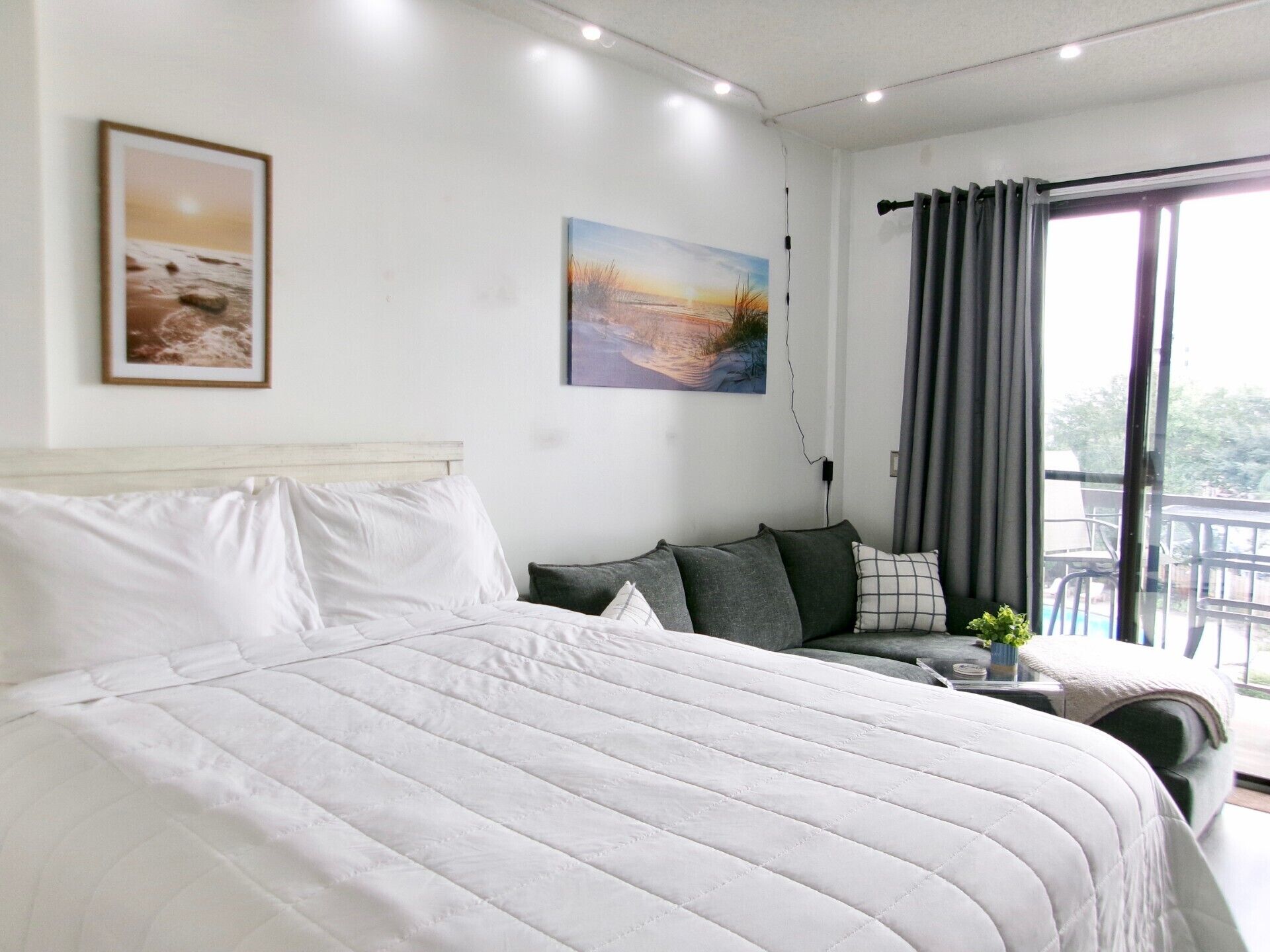 Une chambre avec un grand lit, un canapé et un balcon offrant une vue agréable.