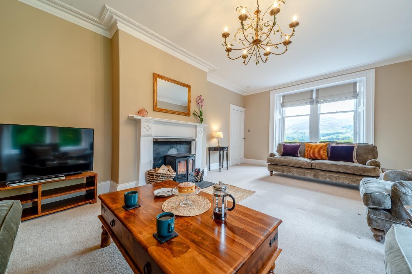 A living room with a fireplace, a television, a sofa, and a coffee table.