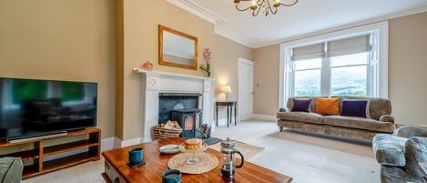 A living room with a fireplace, a television, a sofa, and a coffee table.