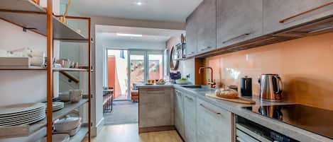 A modern kitchen with a central island, stainless steel appliances, and a view to a patio area.