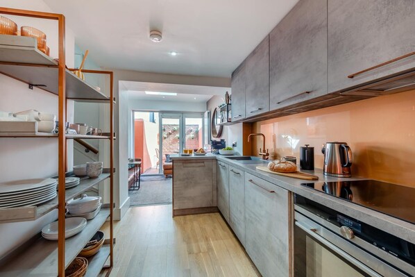 A modern kitchen with a central island, stainless steel appliances, and a view to a patio area.