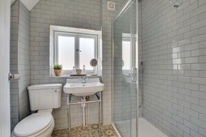 Une salle de bain avec des toilettes, un lavabo et une douche.