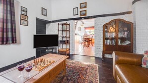 Una sala de estar con una mesa de centro de madera, un televisor y una estantería.