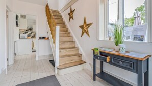 A modern interior with a wooden staircase, a desk with a plant, and a window with a view. - 3 Bed in Forden (oc-c30173) (Forden)
