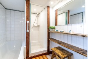 A modern bathroom with a glass-enclosed shower, a wooden bench, and a shelf with toiletries. - 1 Bed in Banningham (oc-564) (Banningham)
