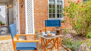 A brick house with a wooden table and chairs outside, a window, and a door. - 2 Bed in East Brent (oc-k32780) (East Brent)