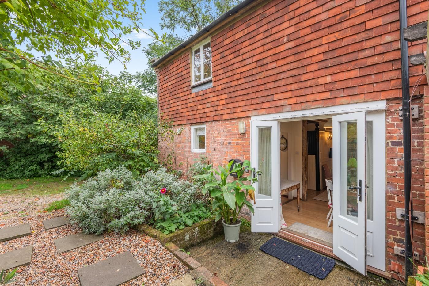 A brick house with a white door and a small window.