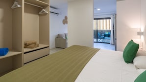 A modern bedroom with a bed, a walk-in closet, and a view of an outdoor balcony. - Golden Sunrise By CanariasGetaway (Mogán)