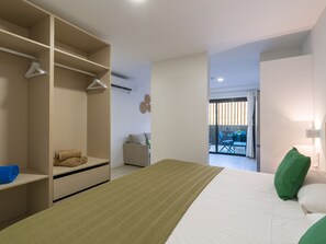 A modern bedroom with a bed, a walk-in closet, and a view of an outdoor balcony. - Golden Sunrise By CanariasGetaway (Mogán)