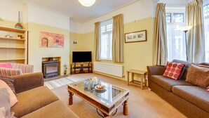 A cozy living room with a fireplace, a television, and comfortable seating.