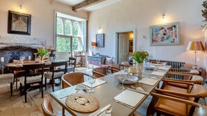 A dining area with a fireplace, large windows, and a view of the outdoors.