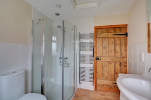 A bathroom with a glass-enclosed shower, a wooden door, and a white sink. - 2 Bed in Bodham (oc-1303) (Bodham)