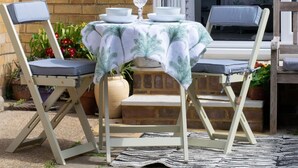 An outdoor dining area with a table set for two, two chairs, and a small potted plant. - 1 Bed in Saltdean (oc-bbidre) (Saltdean)