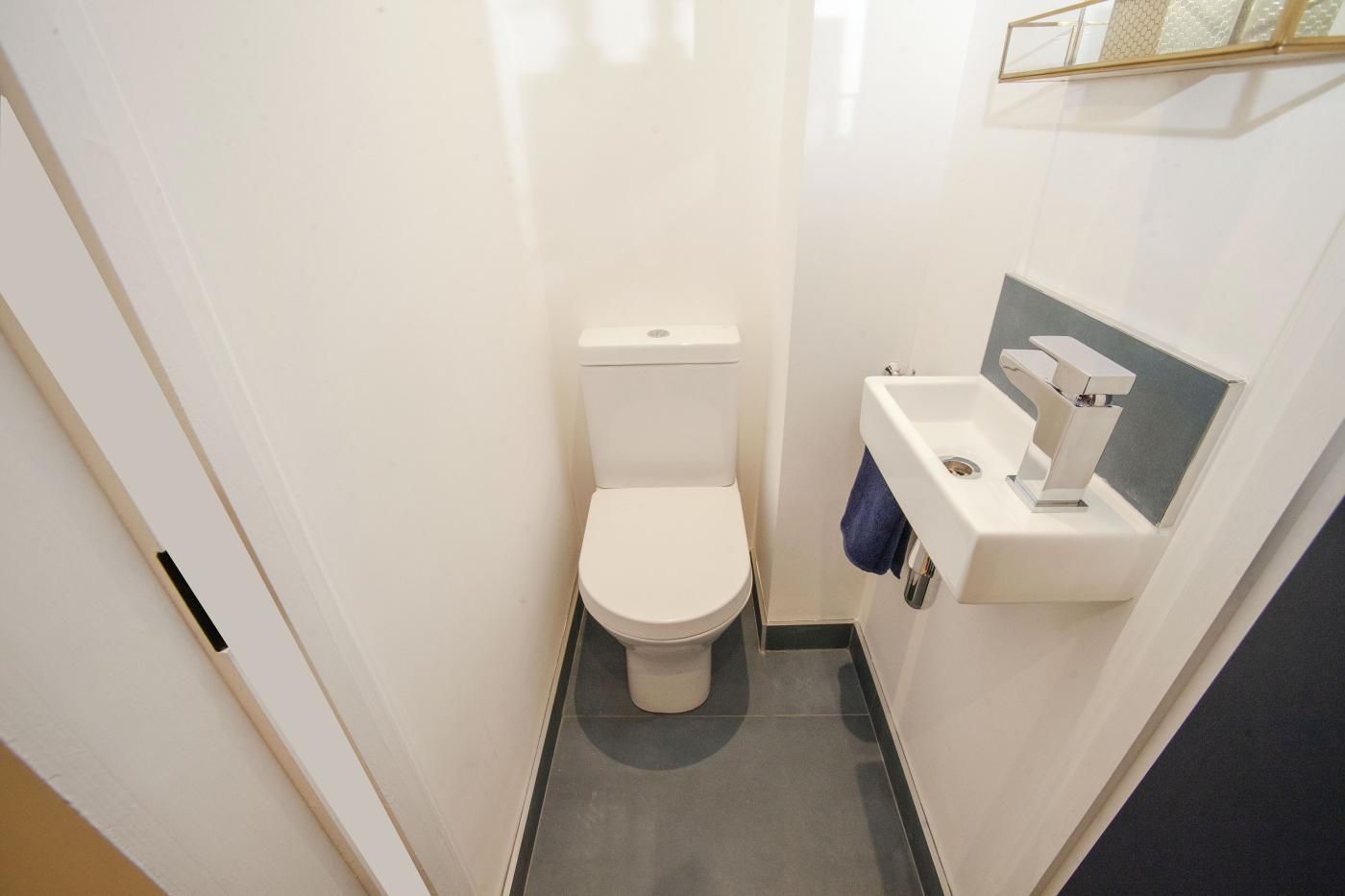 A small, modern bathroom with a toilet and a sink.