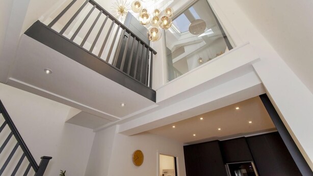 A modern interior with a staircase leading to a mezzanine level, a chandelier, and a visible washing machine. - 2 Bed in Bath (oc-bhr8) (Bath)