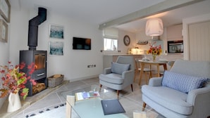 A modern living room with a fireplace, a dining area, and a kitchen. - 1 Bed in Cranbrook (oc-cb652) (Cranbrook)