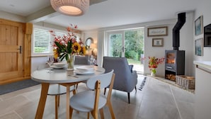 A dining area with a round table, two chairs, a vase with flowers, and a fireplace. - 1 Bed in Cranbrook (oc-cb652) (Cranbrook)