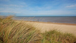 A beach with sand dunes and a clear sky. - 3 Bed in Eccles Beach (oc-852) (Eccles-on-Sea)