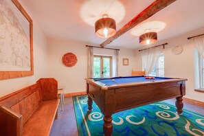 A pool table with a blue felt surface, a wooden bench, and a colorful carpet with circular patterns. - 4 Bed in Roughton (oc-1435) (Roughton)