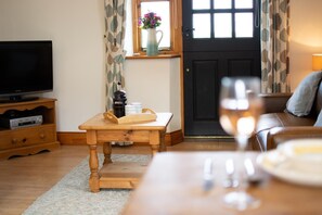 Un salon chaleureux avec une table en bois, un téléviseur et un coin café.