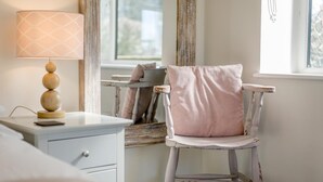 A room with a white desk, a lamp with a patterned shade, a chair with a striped cushion, and a window with curtains. - 3 Bed in Staplecross (oc-rh1162) (Sedlescombe)