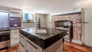 Una cocina moderna con una isla central, horno de ladrillo y estufa de acero inoxidable.