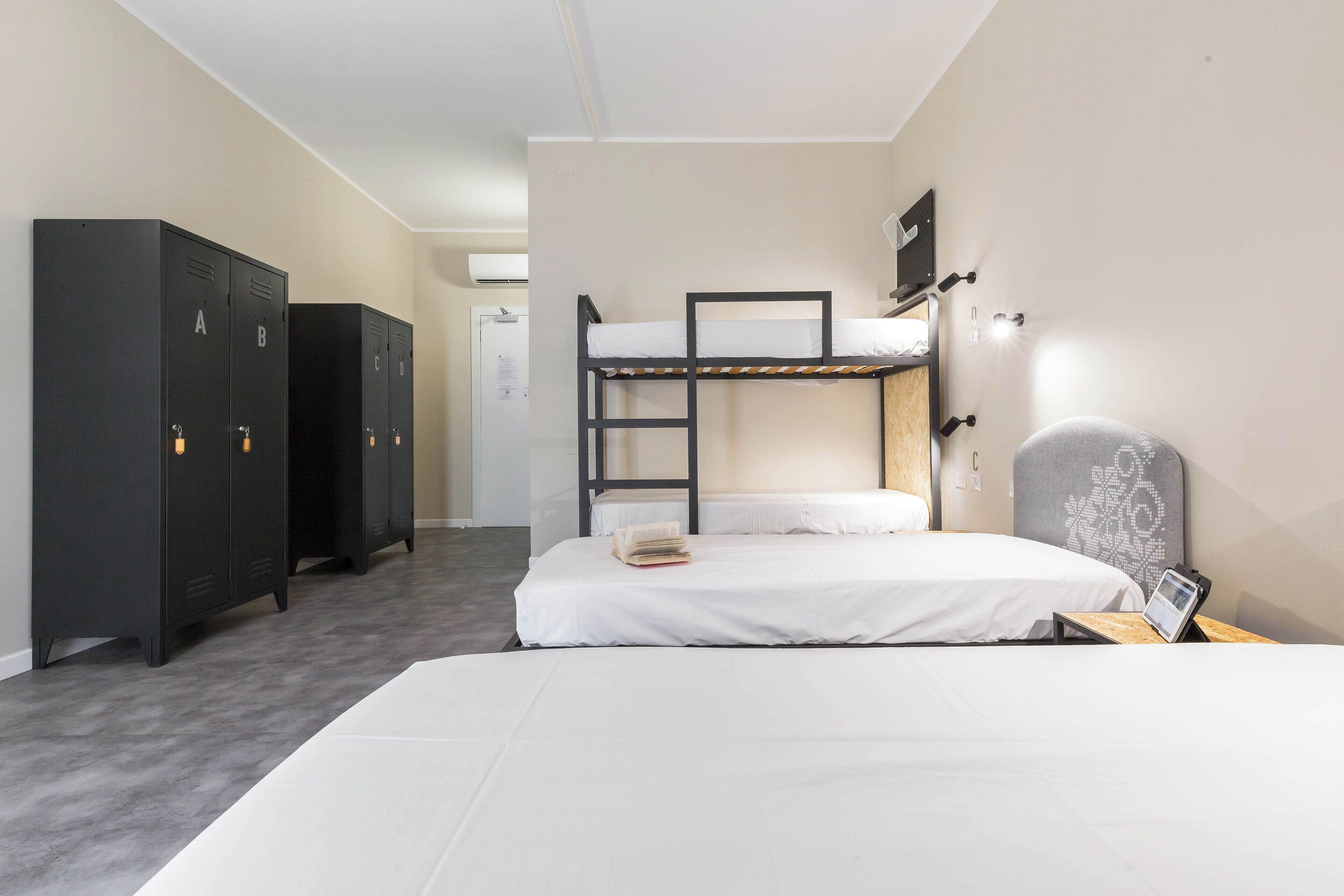Een slaapkamer met een stapelbed, een bureau en een kledingkast.