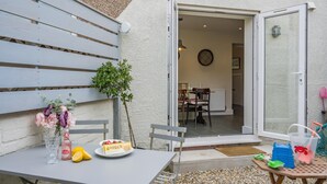 A patio with a table set for two, a small plant, and a snack plate. - 2 Bed in Amble (oc-l32947) (Amble)