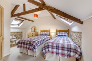 A bedroom with two beds, wooden beams, a skylight, a dresser, and a chair. - 2 Bed in Field Dalling (oc-421) (Field Dalling)