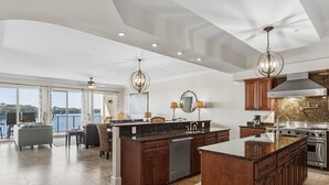 A spacious kitchen with dark wood cabinets, a large island, and stainless steel appliances. - Family Friendly Beachfront Escape (Santa Rosa Beach)