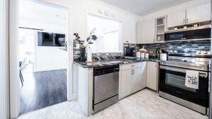 Una cucina moderna con elettrodomestici in acciaio inossidabile, lavastoviglie e forno a microonde.